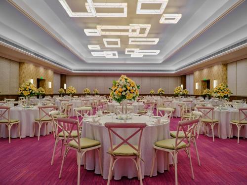 a banquet hall with tables and chairs and flowers at Holiday Inn Resort Goa, an IHG Hotel in Cavelossim