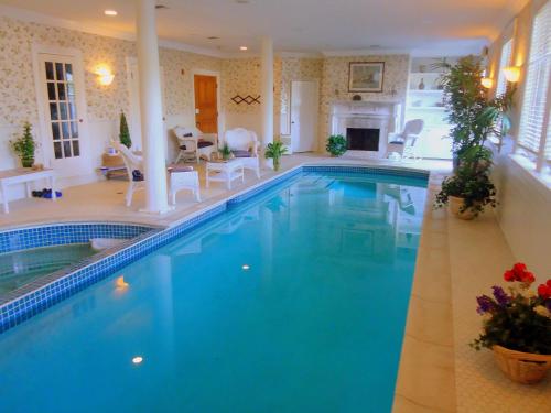 a large swimming pool with blue water in a house at Chiltern Inn in Bar Harbor