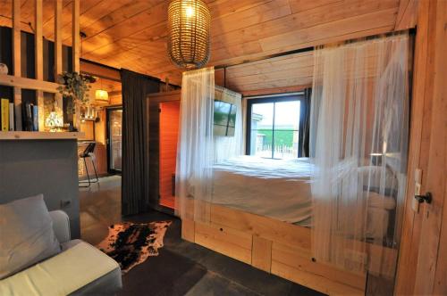 ein Zimmer mit einem Bett in einem Holzhaus in der Unterkunft Duizend en één nacht in Beernem