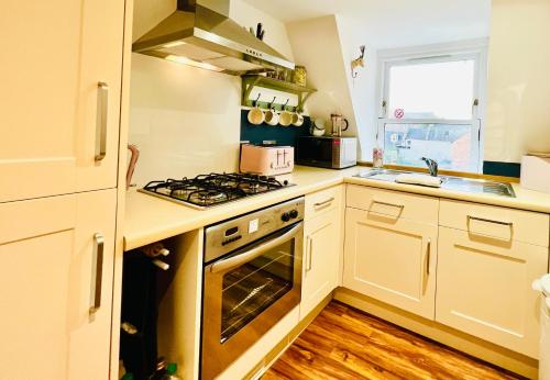 a kitchen with white cabinets and a stove top oven at Stoney Hideaway in Stonehaven