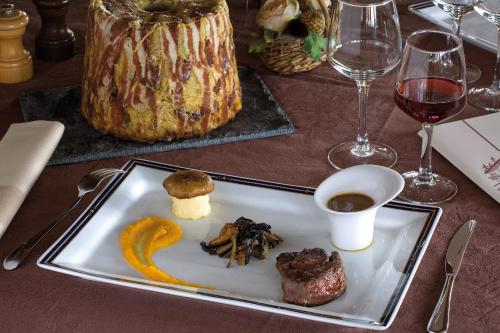 a plate of food on a table with wine glasses at Le Calgary in Les Saisies