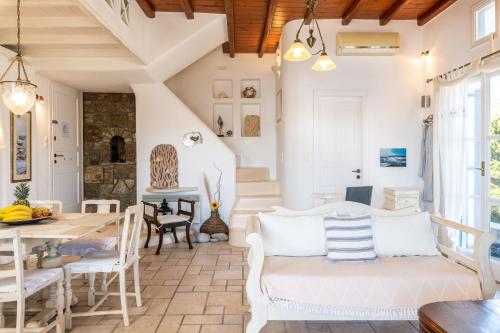 a living room with a white couch and a table at Yalos Mykonos Ornos Pouli private apartments w shared swimming pool in Mýkonos City