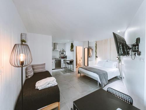 a room with two beds and a desk and a kitchen at -SKY- Appartement meublé cosy & confort-Parking privé & jardin in Laveyron