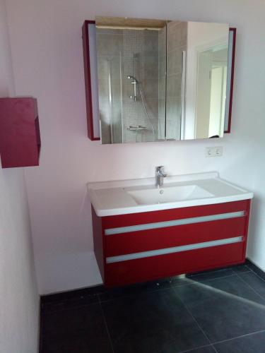 baño con lavabo rojo y blanco y espejo en Comfortable room with double bed, en Vichten