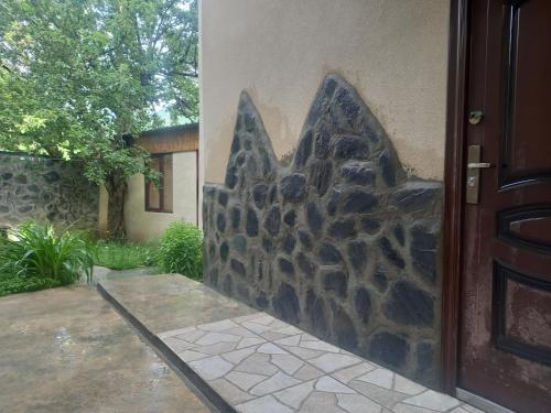 a door to a house with a stone wall at Spardishi tower in Mestia