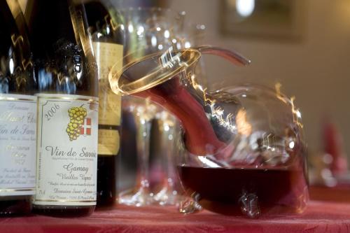 a glass jar of wine on a table with bottles of wine at Le Calgary in Les Saisies