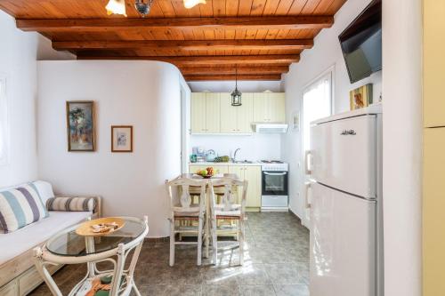 a kitchen and living room with a refrigerator and a table at Yalos Mykonos Ornos Pouli private apartments w shared swimming pool in Mýkonos City