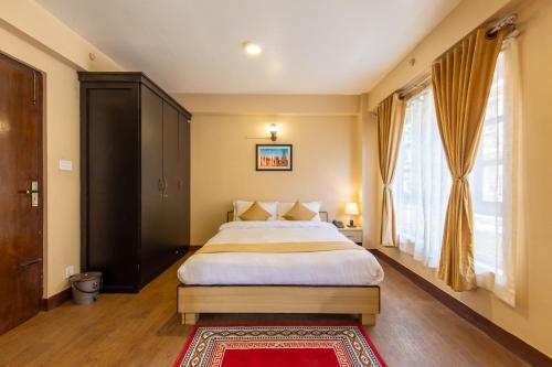 um quarto com uma cama grande e uma janela em Bhrikuti Stay em Patan