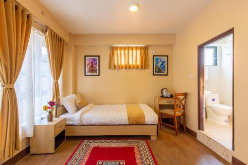 um quarto com uma cama, um WC e uma janela em Bhrikuti Stay em Patan