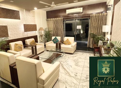 a living room with white couches and a table at Royal Palms Luxury Service Apartment in Nagpur