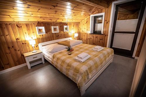 sypialnia z łóżkiem w drewnianym domku w obiekcie Apartamenty MIODZIO w Szczyrku