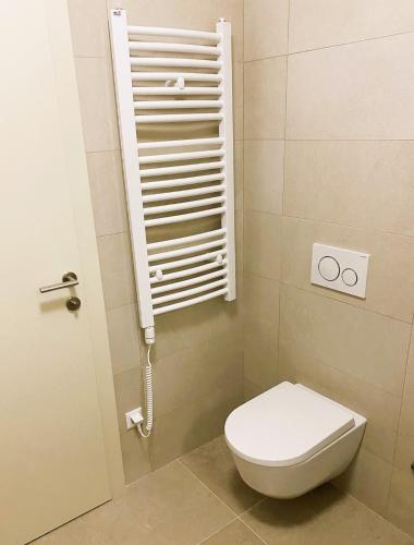 a bathroom with a toilet and a white shutter at Arte Oliva in Grebaštica