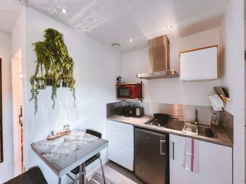 a small kitchen with a small table in a room at -WOOD- Appartement meublé cosy & confort-Parking privé & jardin in Laveyron