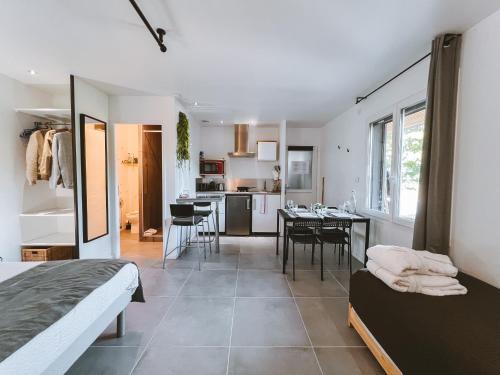 una camera con letto e una cucina con tavolo di -WOOD- Appartement meublé cosy & confort-Parking privé & jardin a Laveyron