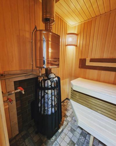 a sauna with a heater and a bed in it at По Щучьему Велению in Shchūchīnsk