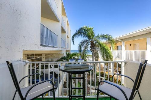 a balcony with chairs and a table and palm trees at 201 Belleair Beach Club in Clearwater Beach
