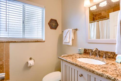 een badkamer met een wastafel, een toilet en een spiegel bij 201 Belleair Beach Club in Clearwater Beach