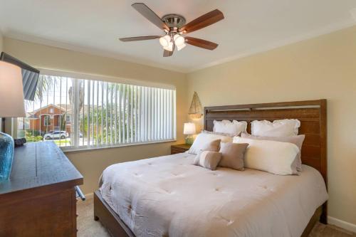 a bedroom with a bed with a ceiling fan and a window at 201 Belleair Beach Club in Clearwater Beach