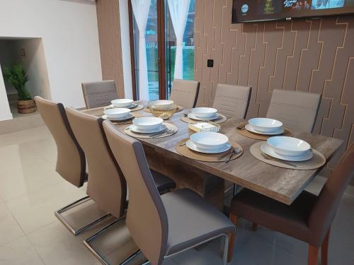 a dining room table with chairs and plates on it at MONADIN Villa Relax & Spa in Săcele