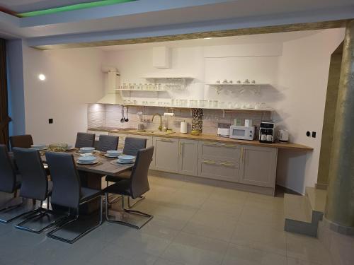 a kitchen and dining room with a table and chairs at MONADIN Villa Relax & Spa in Săcele