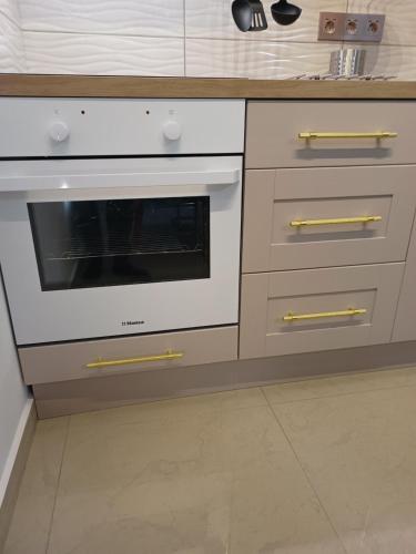 a kitchen with a white oven with gold handles at MONADIN Villa Relax & Spa in Săcele