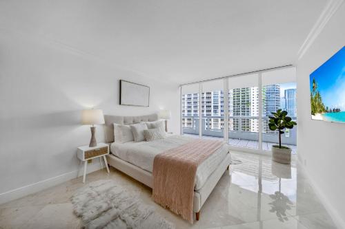 una camera bianca con un letto e una grande finestra di Unforgettable Water Views Oasis a Miami