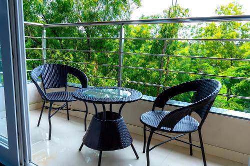 3 chaises et une table sur un balcon avec une fenêtre dans l'établissement Hotel The Classic Verna, à Verna