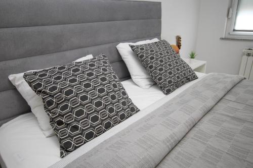 a bed with two pillows on top of it at Apartment IG4U, City center in Bjelovar