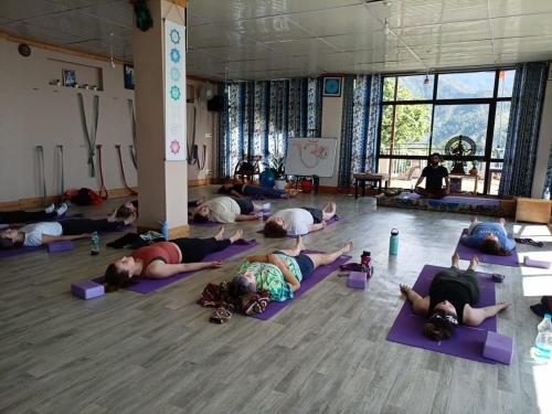 a group of people laying on the floor in a yoga class at Yoga House in McLeod Ganj