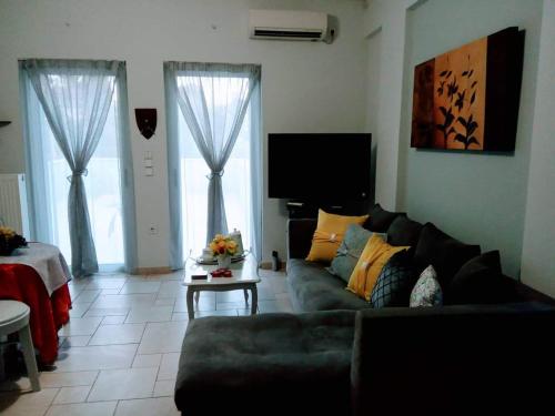 a living room with a couch and two windows at Πέτρινο στη θάλασσα in Nafpaktos