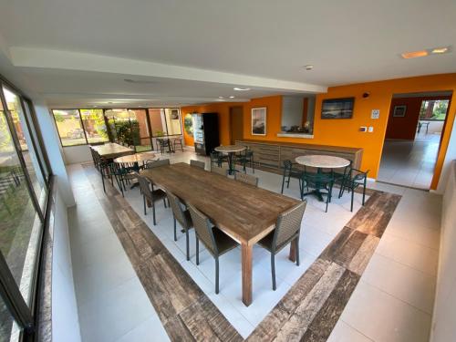 una sala da pranzo con tavoli e sedie in un edificio di Apartamento Cobertura Paraíso das Águas - GUARAJUBA a Camaçari