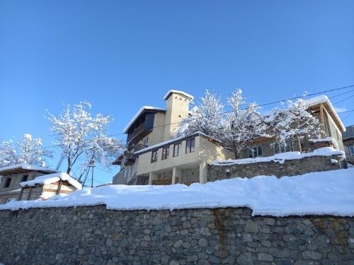 a building on a stone wall covered in snow at Spardishi tower in Mestia