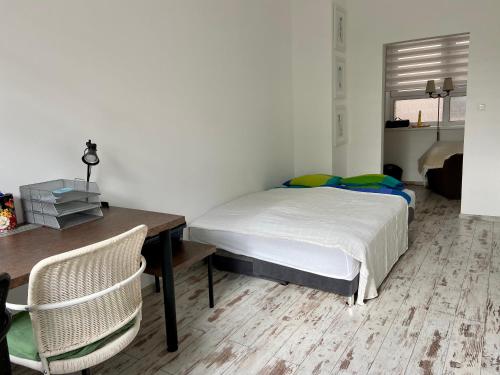 1 dormitorio con 1 cama, mesa y silla en Residence Park lovely apartman with private parking, en Kysucké Nové Mesto