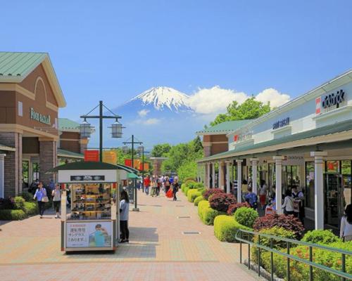 a shopping mall with a snow covered mountain in the background at Hotel Square FujiGotemba in Gotemba