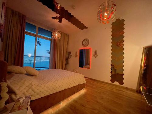 a bedroom with a bed and a large window at Creekview Luxury Apartment in Ajman 