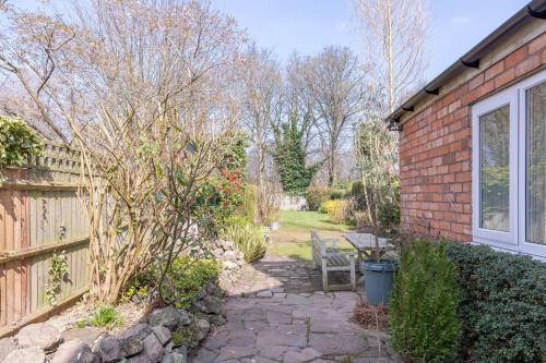 a brick house with a bench next to a fence at Spacious 5 Bedroom House in Birmingham close to NEC For 12 Guests in Birmingham