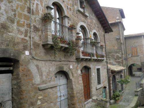 un antiguo edificio de piedra con macetas en los balcones en antica dimora, en Barbarano Romano