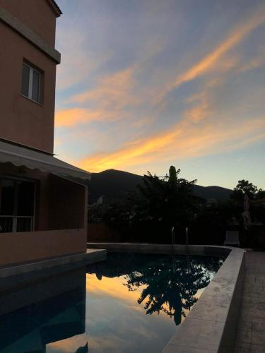a swimming pool with a sunset in the background at Piccadilly in Alykes