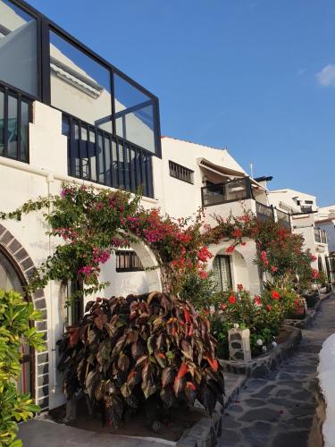 a building with flowers on the side of it at Very romantic seaview appartment with warm pool in Patalavaca
