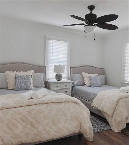 a bedroom with two beds and a ceiling fan at Beautiful Main House in West Palm Beach in West Palm Beach