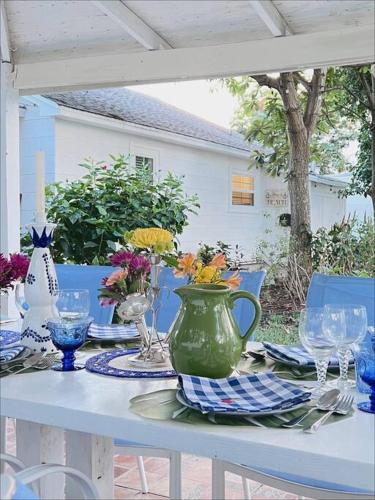 a table with a green vase on top of it at Beautiful Main House in West Palm Beach in West Palm Beach