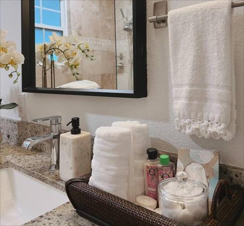 a bathroom with towels and a sink and a mirror at Beautiful Main House in West Palm Beach in West Palm Beach