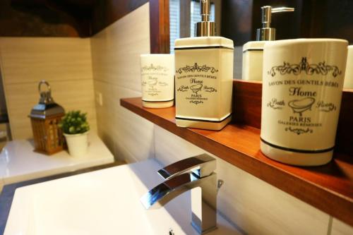La salle de bains est pourvue de 2 bouteilles de savon et d'un lavabo. dans l'établissement Apartment Alte Schusterei, à Freiberg