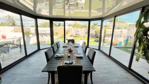 een eetkamer met een lange tafel en stoelen bij Villa DALI LA GARDE 260m2 Jacuzzi, Sauna, Piscine, jardin 500m2, 5 minutes de la Plage in La Garde
