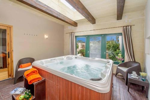una grande vasca da bagno in una stanza con finestra di Djar Ta Menzja 3 Holiday Home a Sannat