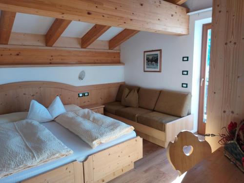 a bedroom with a bed and a couch in a room at DOLOMITI appart&rooms in Varena