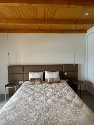 a bedroom with a large bed with two chairs at Refúgio do Vale in Celorico de Basto