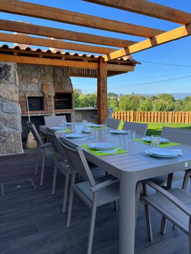 a table and chairs on a deck with a fireplace at Refúgio do Vale in Celorico de Basto
