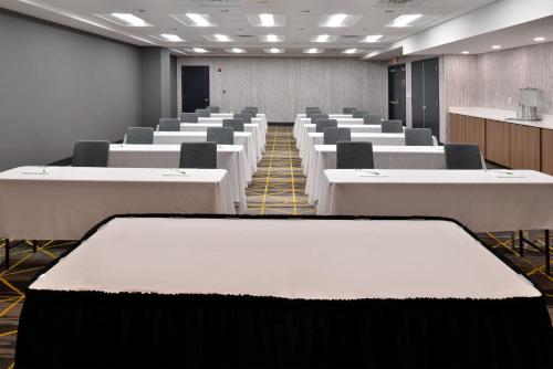 a room with rows of tables and chairs at Holiday Inn Hotel & Suites Overland Park-Convention Center by IHG in Overland Park