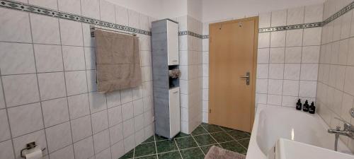 a bathroom with a tub and a shower with a towel at Gemütliche Zwei-Zimmer-Ferienwohnung "W1" in Zwenkau bei Leipzig im Neuseenland in Zwenkau